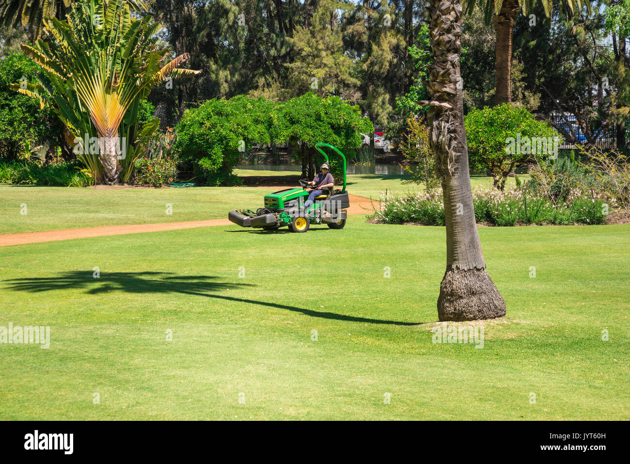 A lawnmower cutting grass in a Government House landscaped park in Perth City, Western Australia Stock Photo