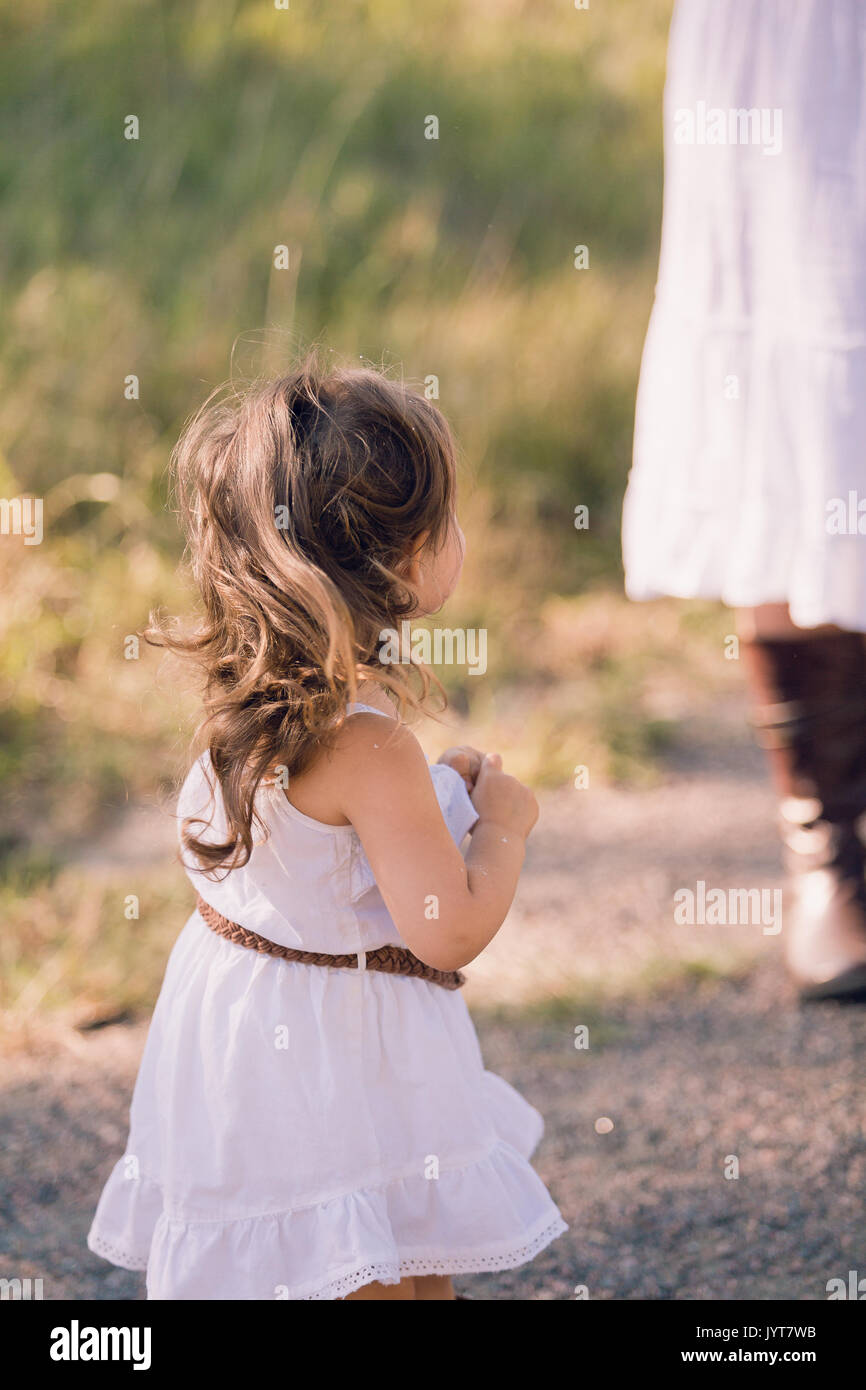 Little girl in a white sun dress playing outside Stock Photo Alamy