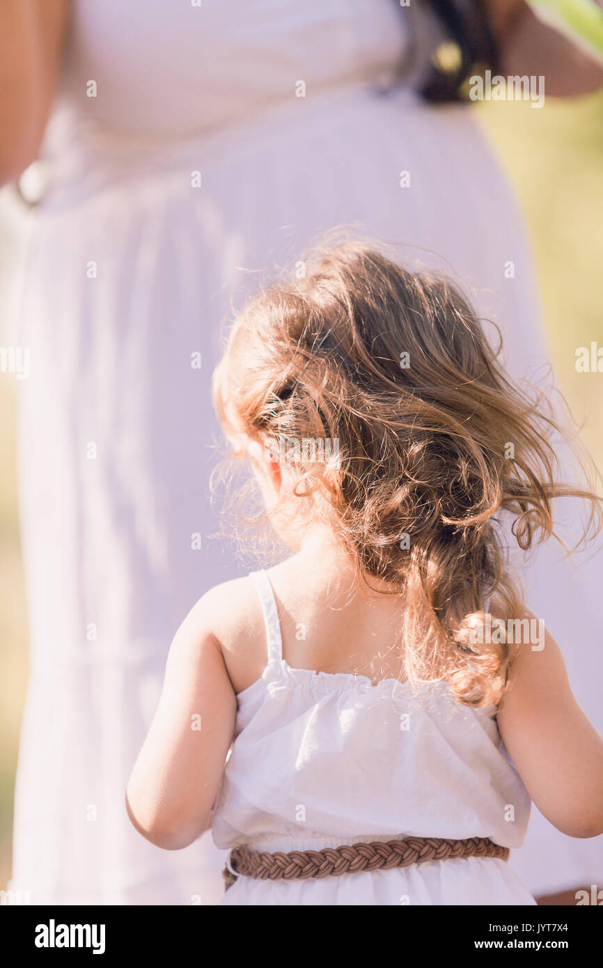 Little girl in a white sun dress at the family photo shoot Stock Photo