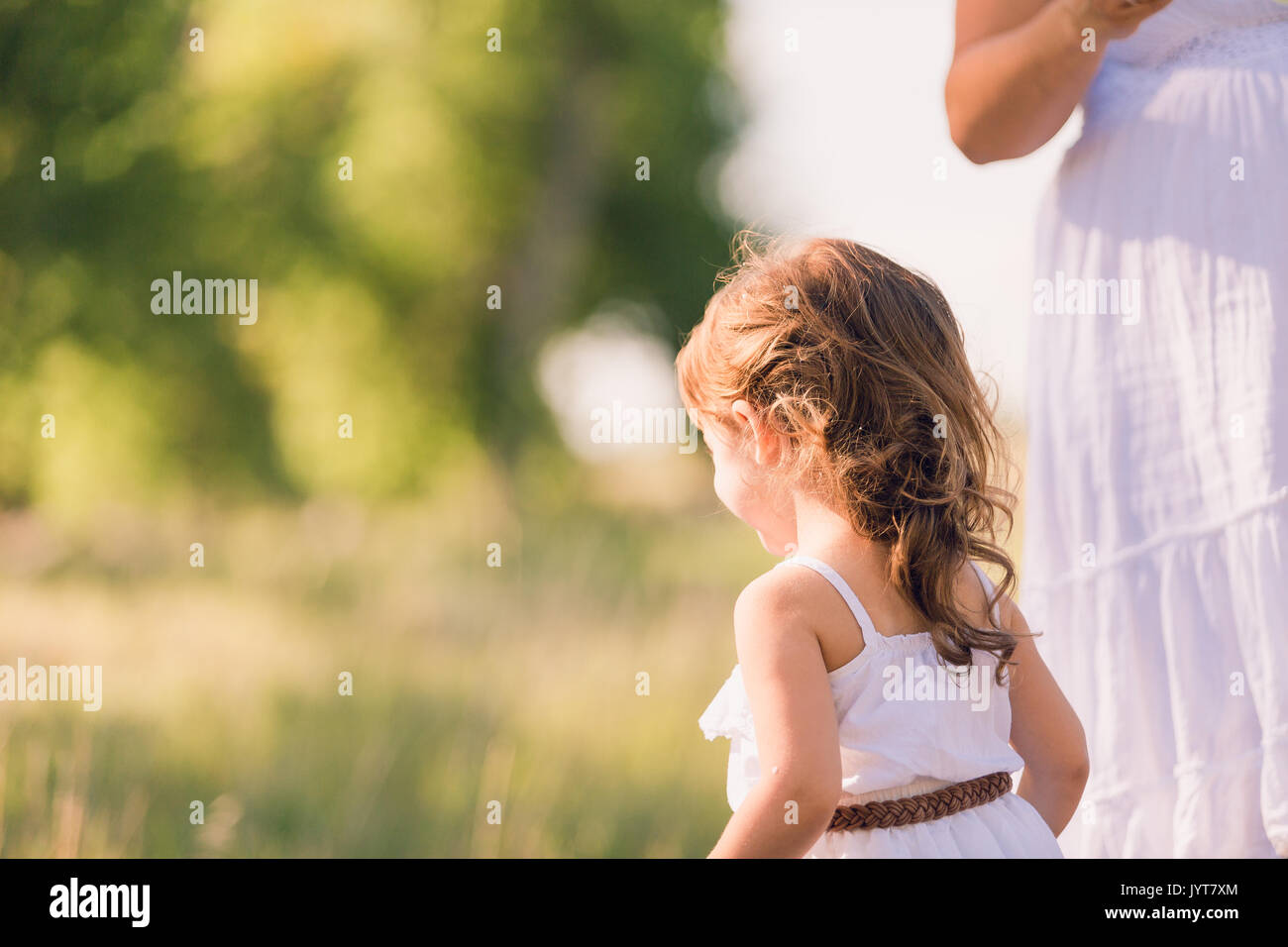 Little girl in a white sun dress at the family photo shoot Stock Photo