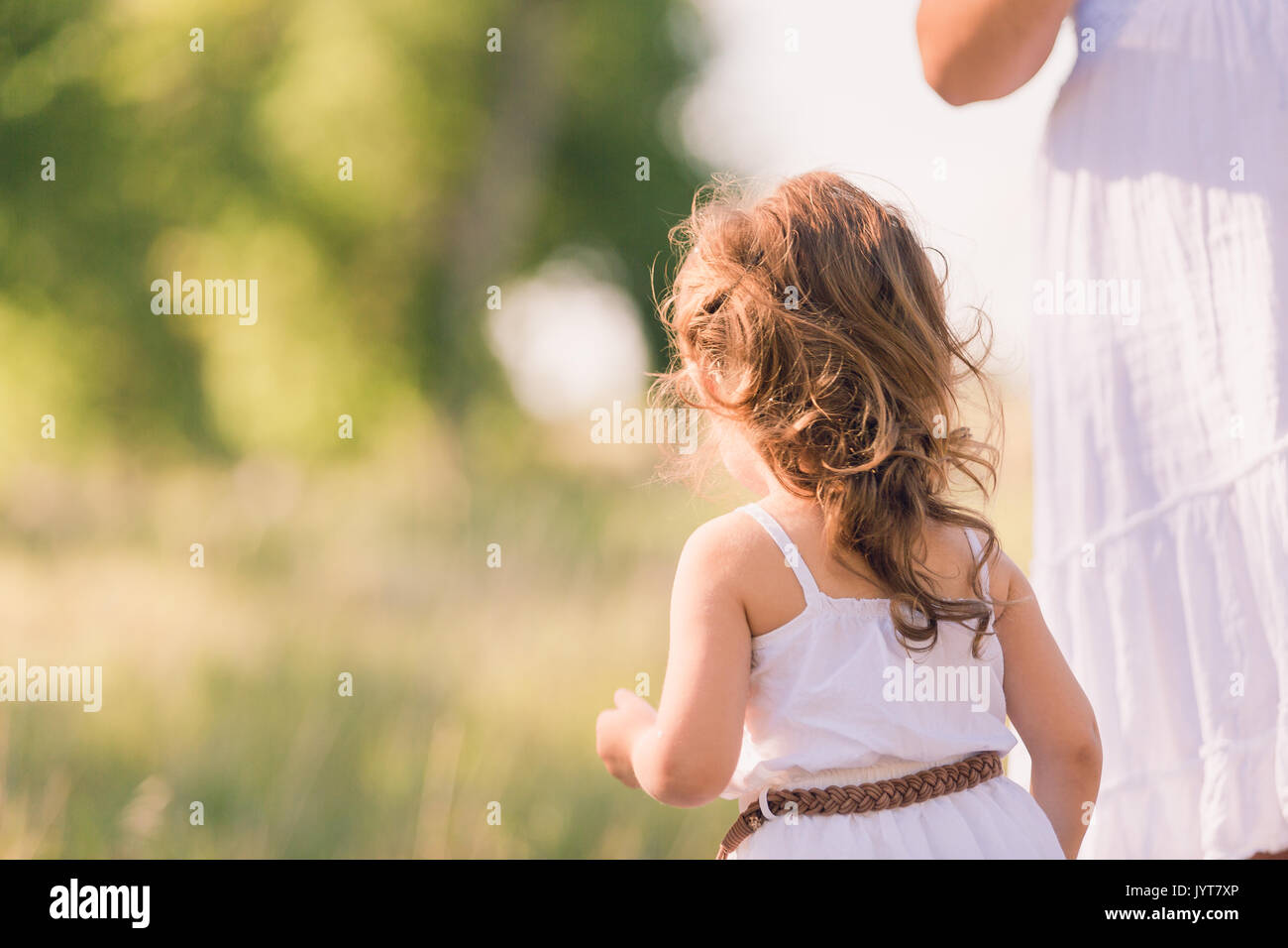 Little girl in a white sun dress at the family photo shoot Stock Photo