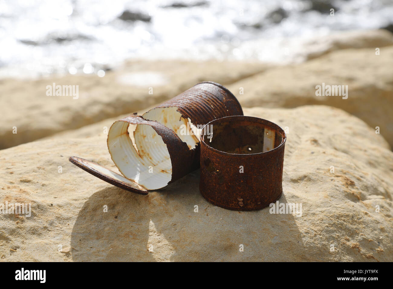 Old rusty cans left on the sea shore Stock Photo