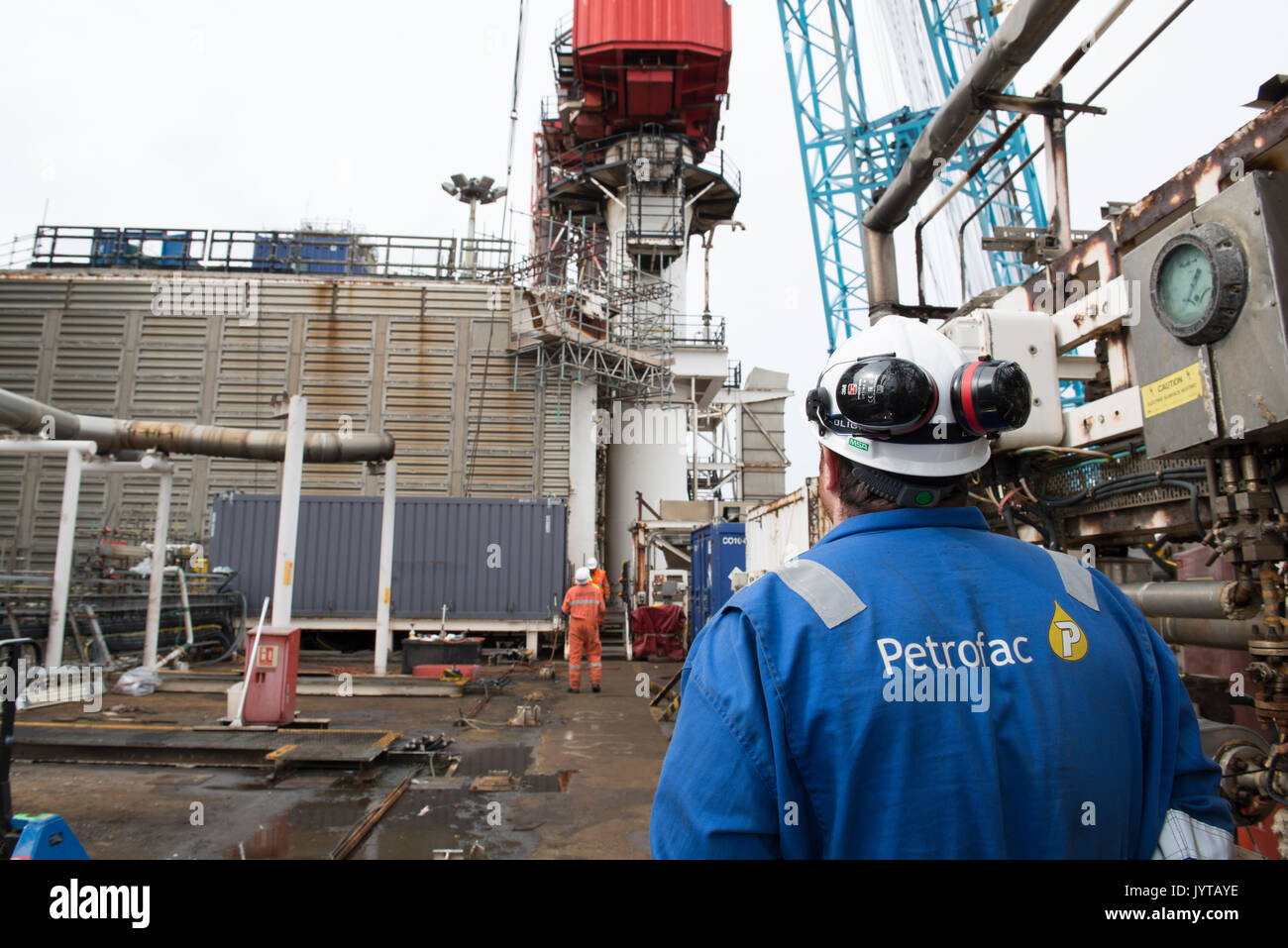 Oil and gas worker, overseeing a lifting operation on a North Sea oil and gas rig. credit: LEE RAMSDEN / ALAMY Stock Photo