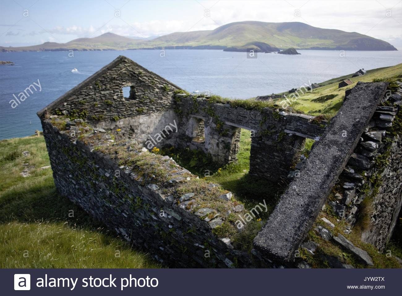 A view of the Great Blasket Island off the West Coast of ireland showing stone houses in which people lived and the Blasket Sound stretch of the ocean Stock Photo