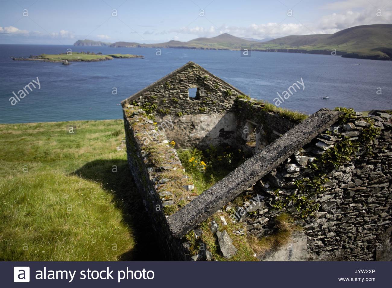 A view of the Great Blasket Island off the West Coast of ireland showing stone houses in which people lived and the Blasket Sound stretch of the ocean Stock Photo