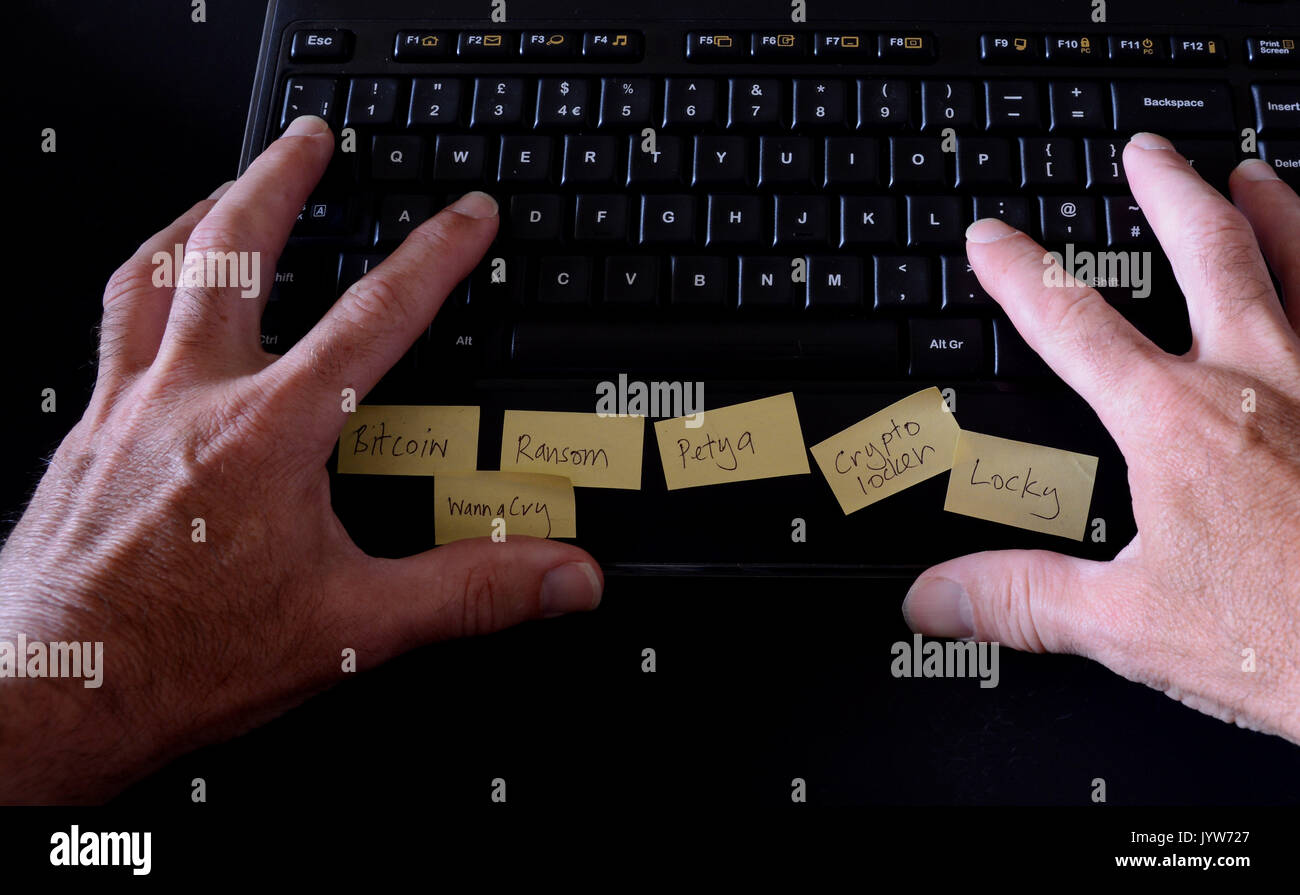 Man typing on computer keyboard with post it notes on depicting ...