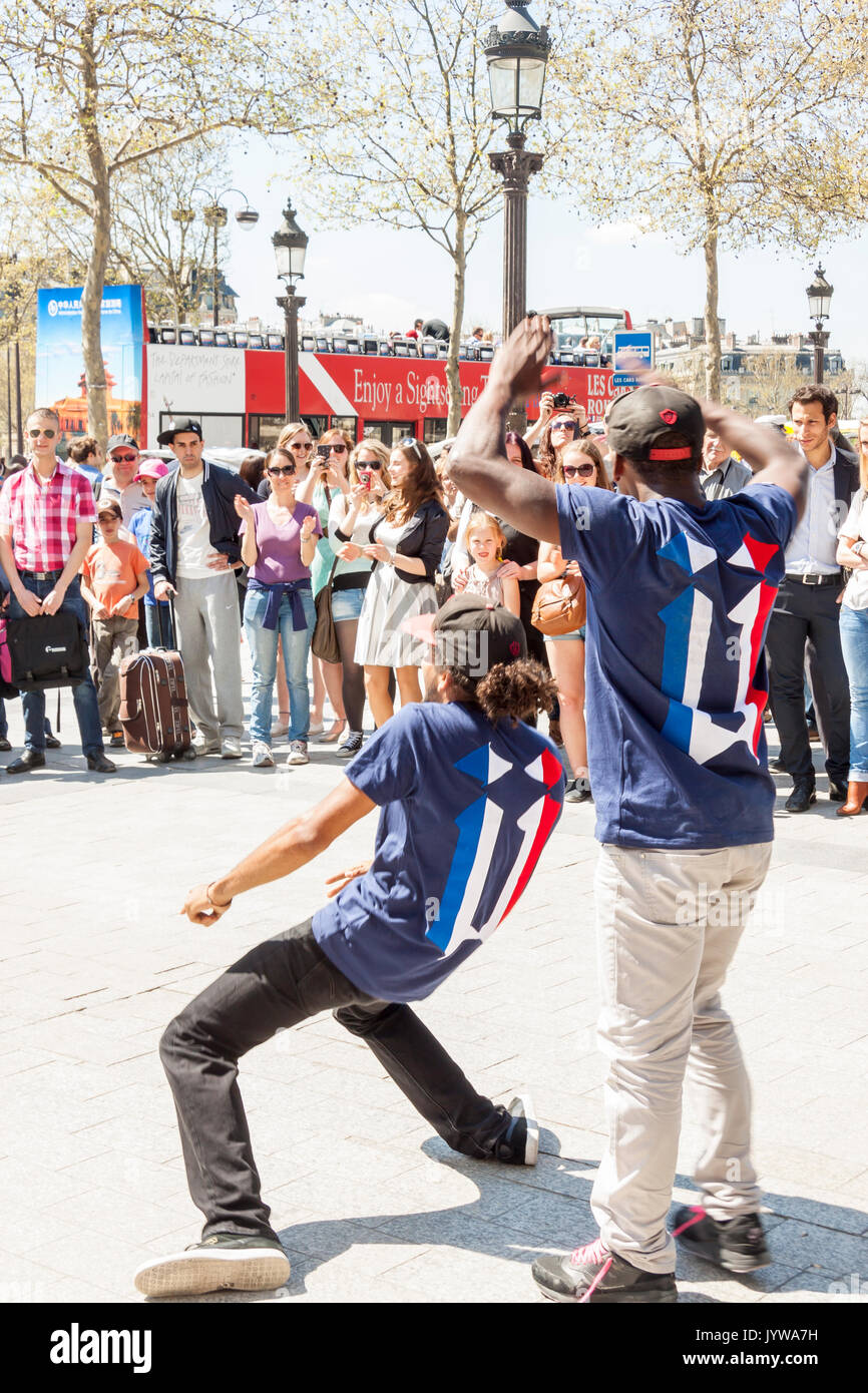 PARIS, FRANCE -  APRIL 25:B-boy doing some breakdance moves in front a street crowd, at Arch of Triumph on april 25, 2013 in Paris. Its popular form o Stock Photo