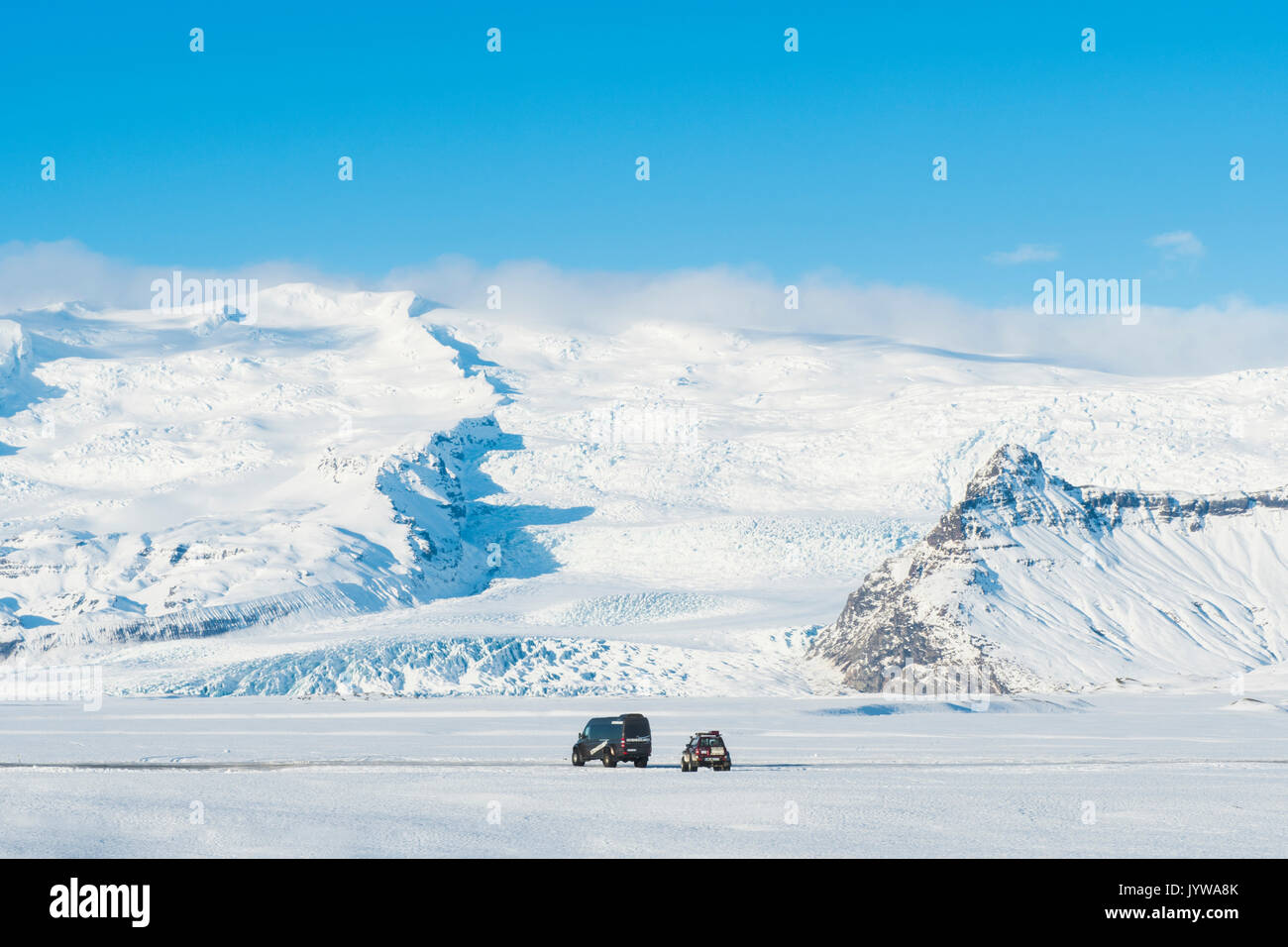 East Iceland, Iceland. Big off-road cars parked in the snow and snow capped mountains in winter. Stock Photo