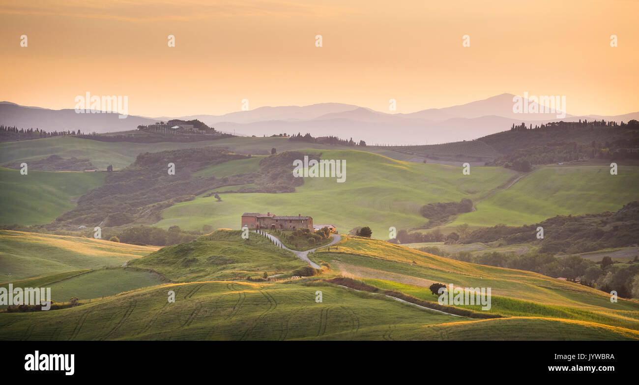 San Quirico d'Orcia, Tuscany, Italy. Podere surrounded by hills, during a warm sunrise. Stock Photo