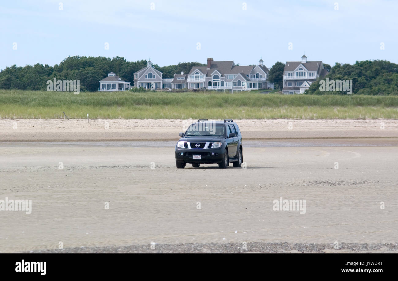 Four wheeling on Cold Storage Beach with upscale home in the background  - Dennis, MA - Cape Cod Stock Photo