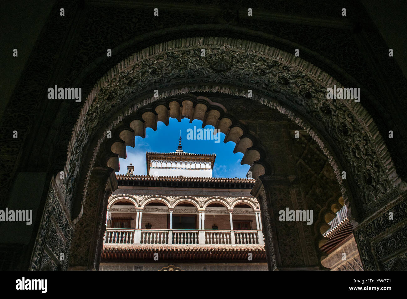 Spain: the Patio de las Doncellas, theCourtyard of the Maidens of the King Peter I Palace, seen from an horseshoe arch in the royal Alcazar of Seville Stock Photo