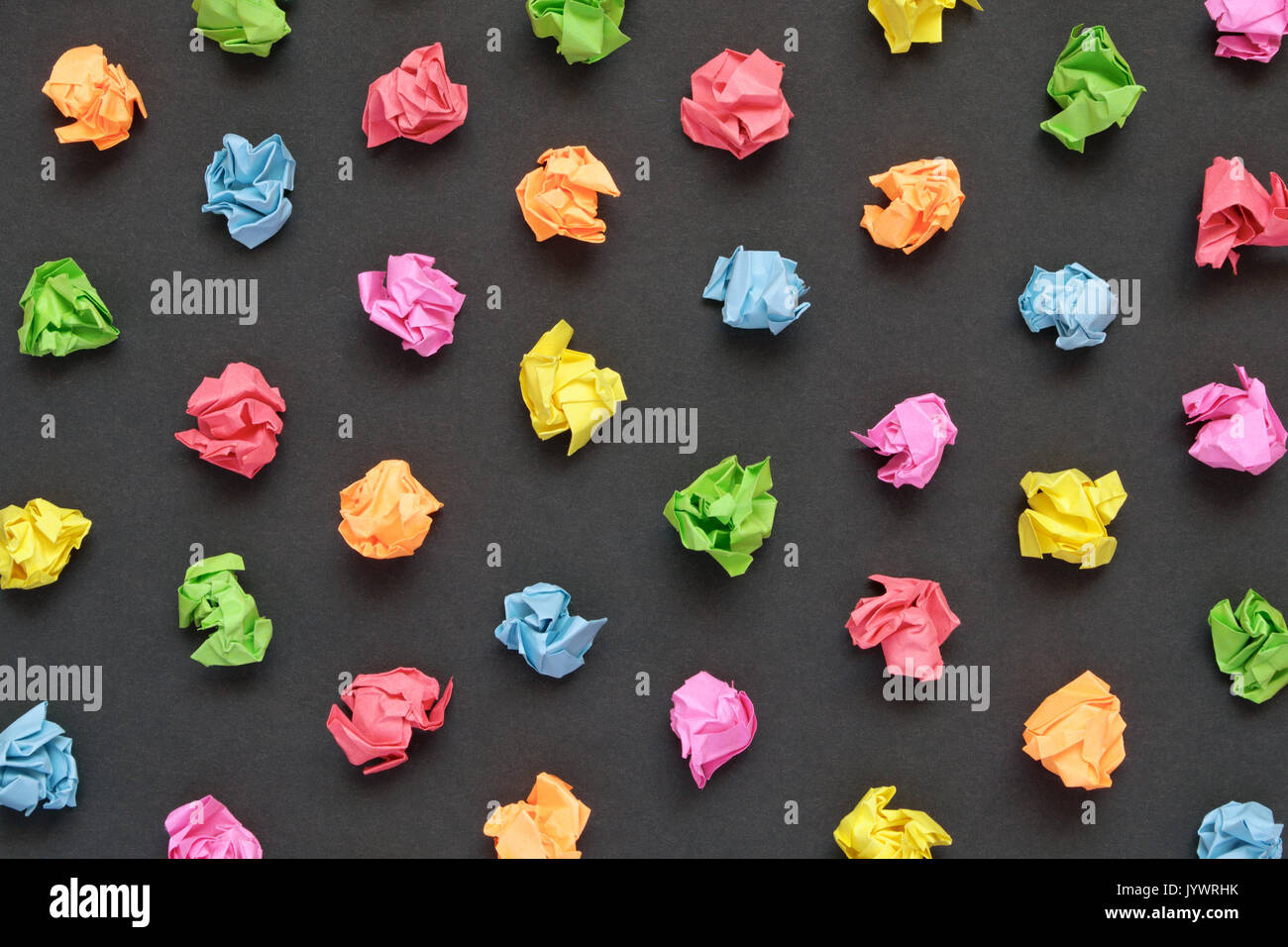 Colorful crumpled papers on black paper background Stock Photo