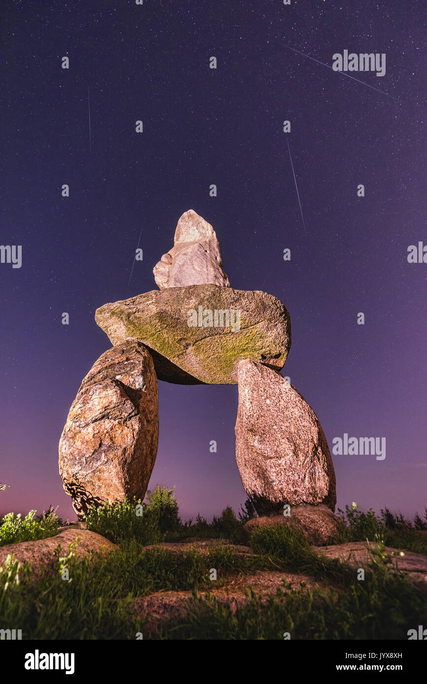 Abandoned stones under night sky with falling Perseid Stock Photo
