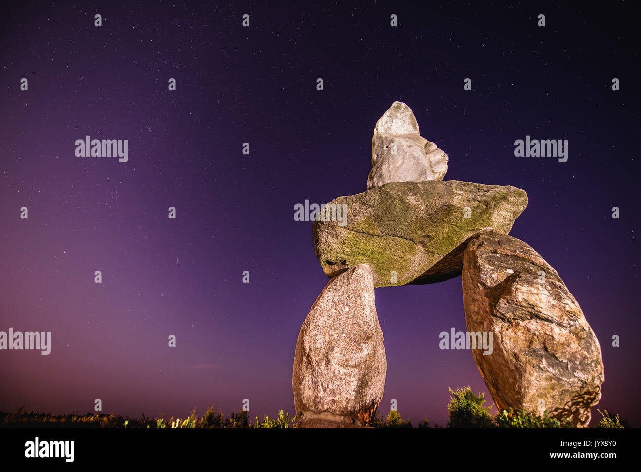 Abandoned stones under night sky with falling Perseid Stock Photo