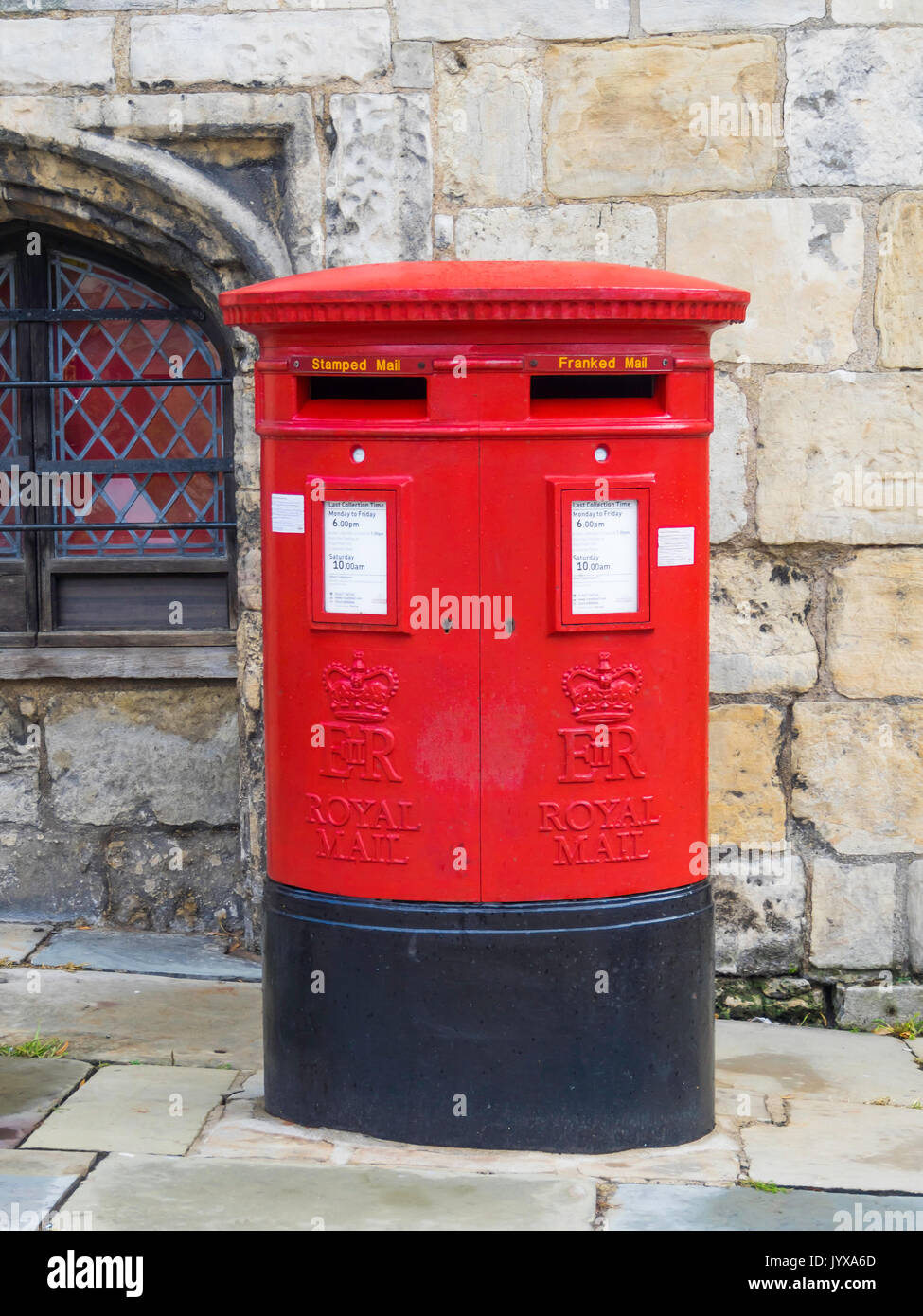 A traditional red double fronted Royal Mail post box with boxes labelled for “Stamped” and