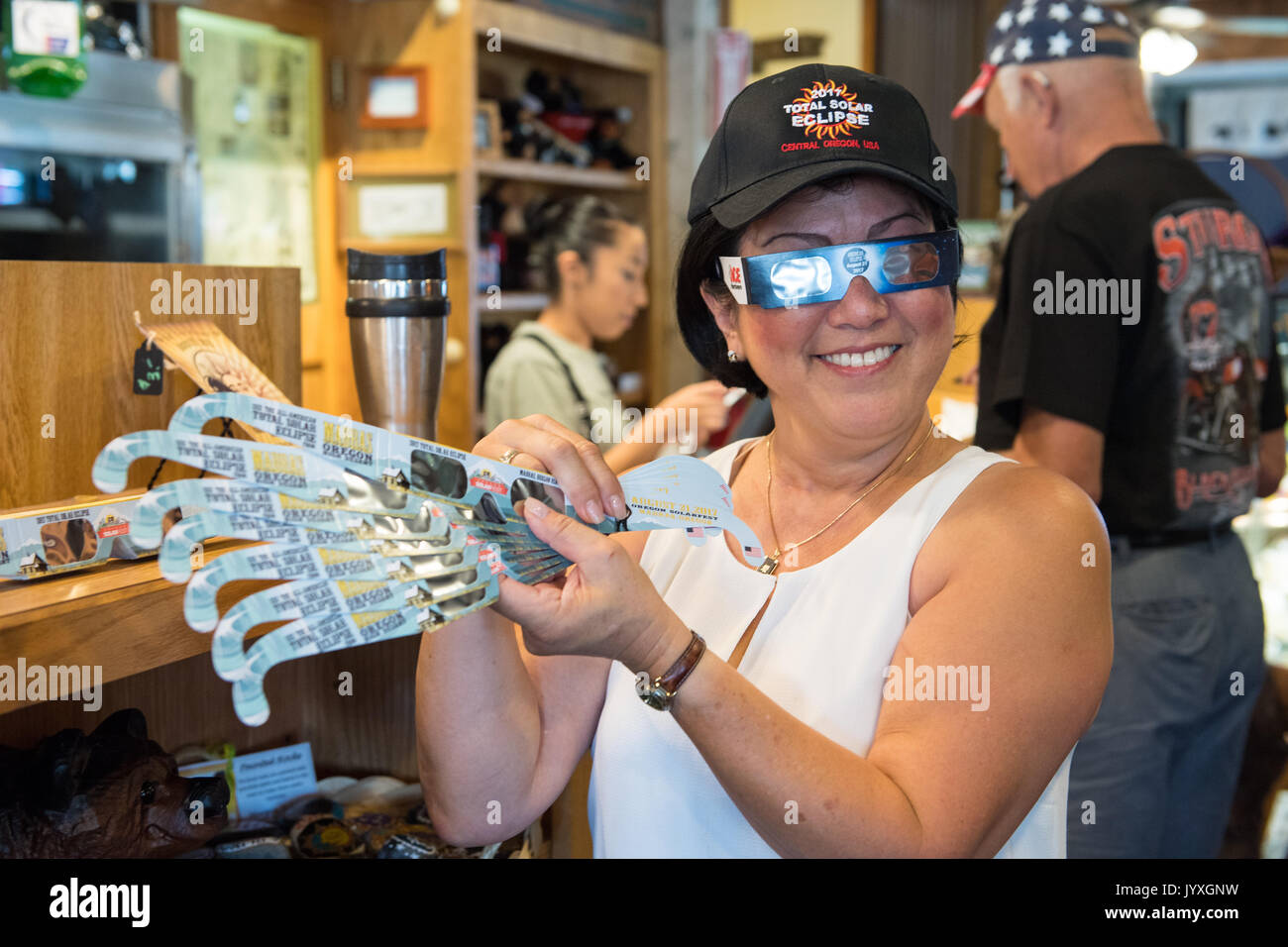 Carol Jensen, holds up solar glasses for sale at Black Bear Diner August 19, 2017 in Madras, Oregon. Jensen is volunteering to help prepare for the crowds arriving to watch the total solar eclipse. The eclipse will be sweeping across a narrow portion of the contiguous United States from Lincoln Beach, Oregon to Charleston, South Carolina on August 21, 2017. Stock Photo