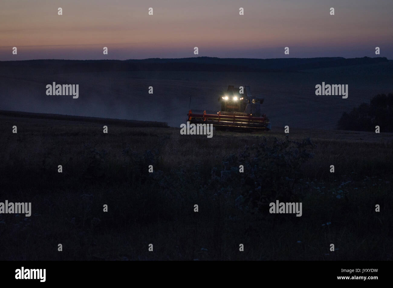 Night harvest, harvesters are reaping on a wheat field Stock Photo Alamy