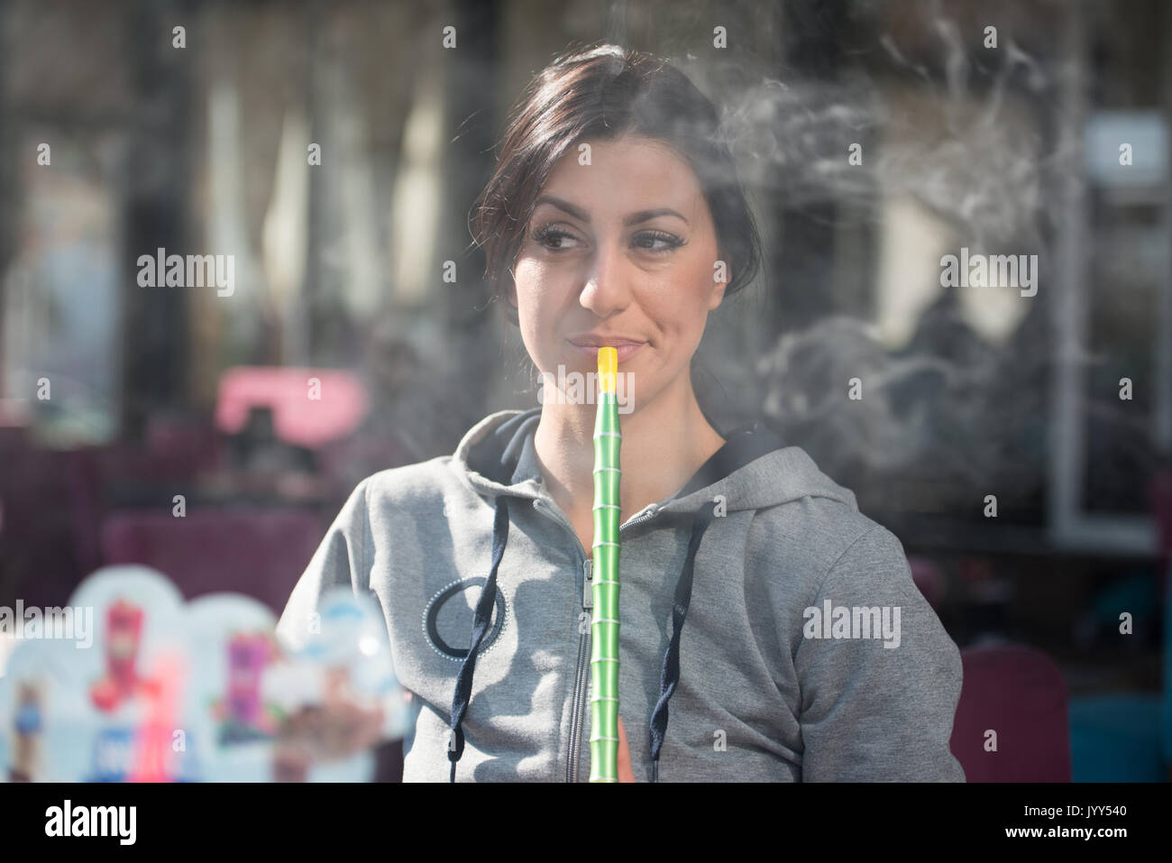 Young Woman Smoking Shisha Outdoors - Female Exhaling Smoke Inhaling From A Hookah Stock Photo