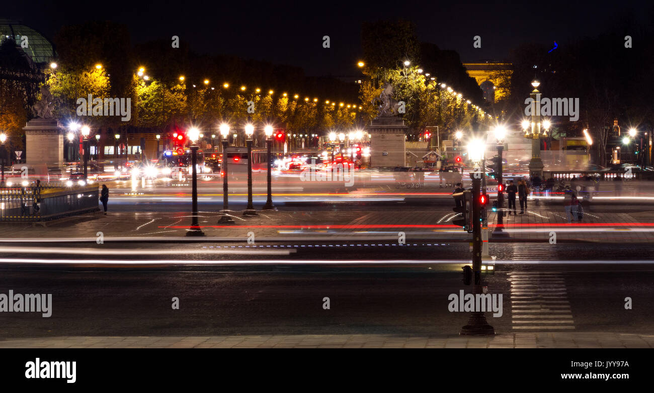 Landmark and touristic spot: Champs-Elysees avenue and Concorde square in Paris, France, at night with streetlights, cars and intensive traffic. Stock Photo