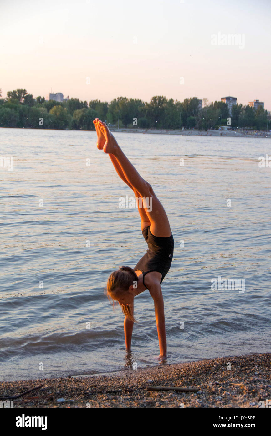A little girl make hand stand, front walkover, back walkover, cartwheel, wolf jump, elbow stand Stock Photo