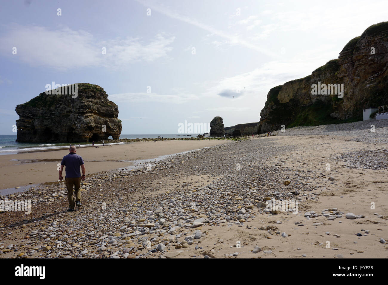 People on the beach at Marsden Rock a Rocky Formation of Limestone  off the North Sea Coast in South Shields England Stock Photo