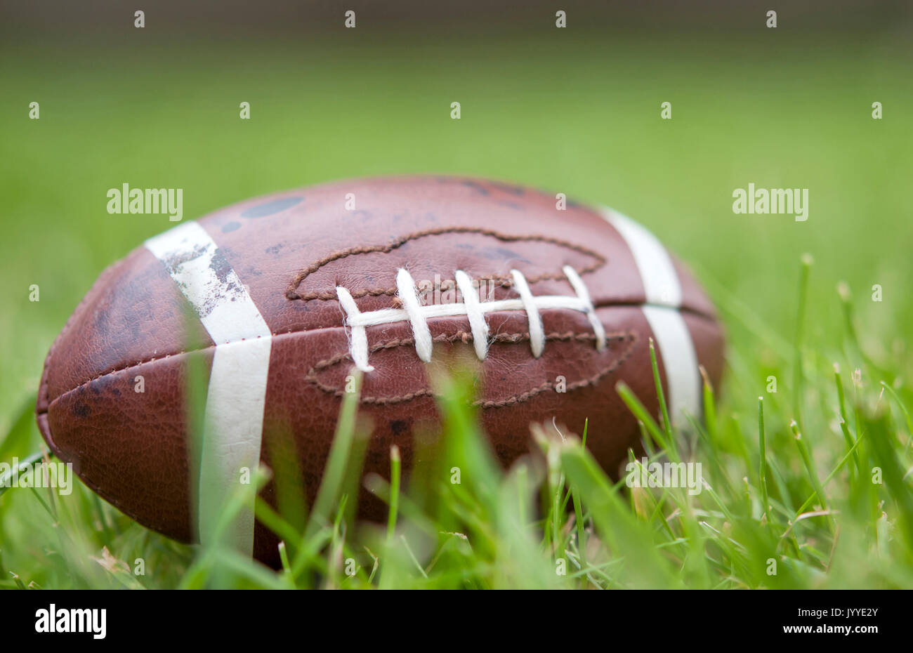American football isolated laying in the summer grass Stock Photo