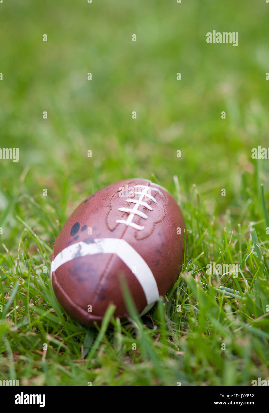 american football isolated laying in the summer grass Stock Photo