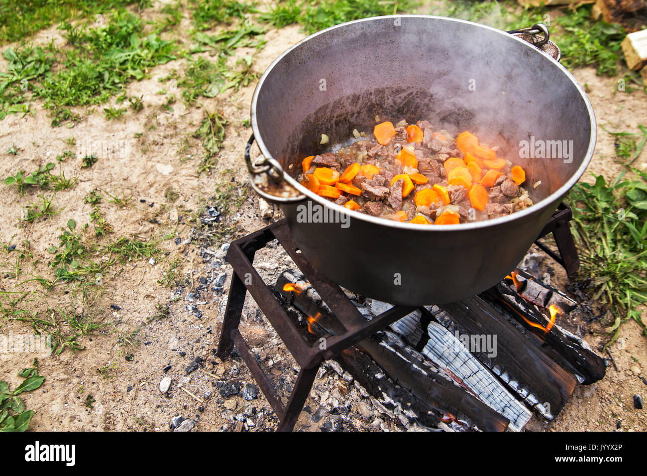 Cooking soup in cast iron boiler on burning campfire. Pot with soup over  the open fire outdoors. Tourism in Latvia. Soup cooking on the fire outdoor  f Stock Photo - Alamy