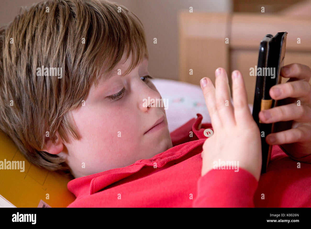 young boy lying on his bed with his smartphone Stock Photo - Alamy