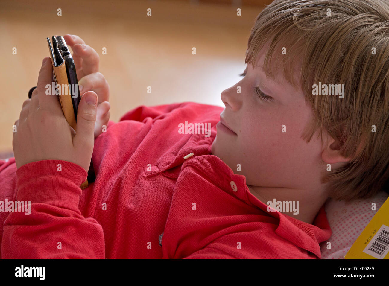 young boy lying on his bed with his smartphone Stock Photo - Alamy