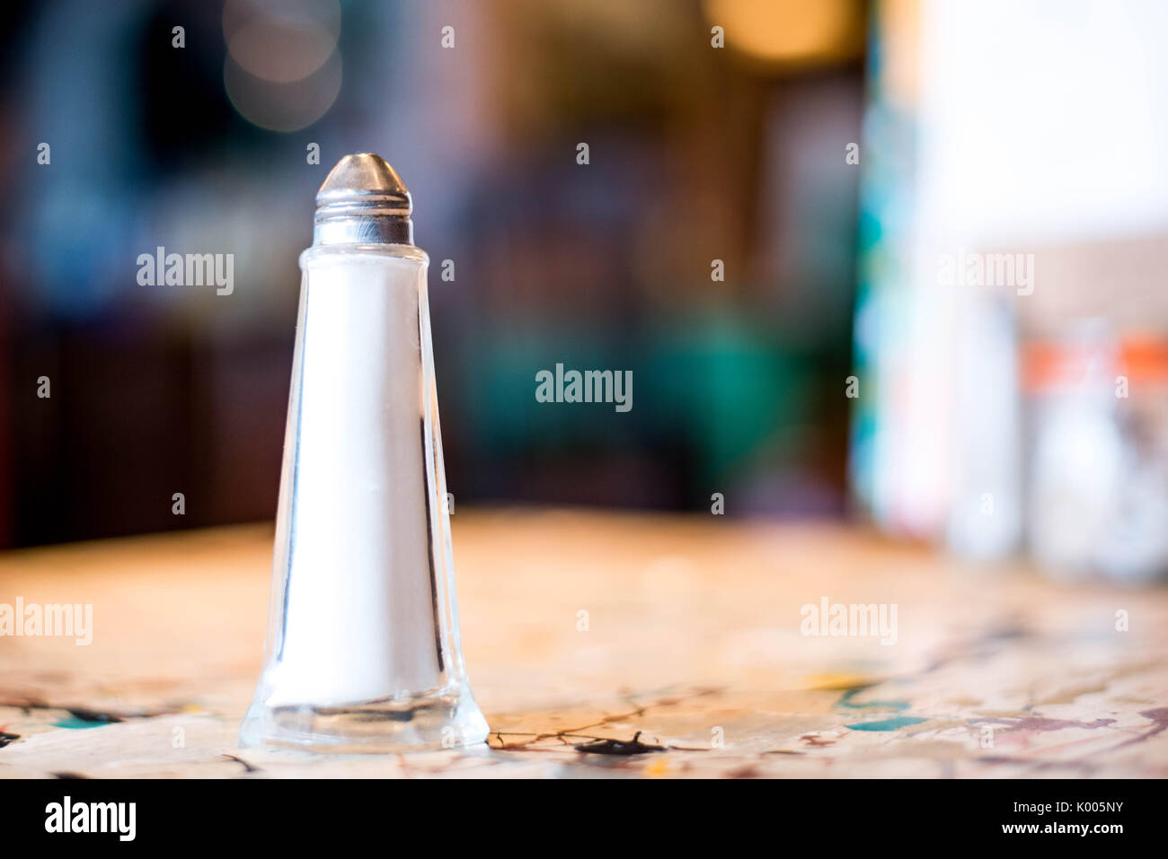 Single Salt Dispenser Or Shaker On A Restaurant or Cafe Table Stock Photo