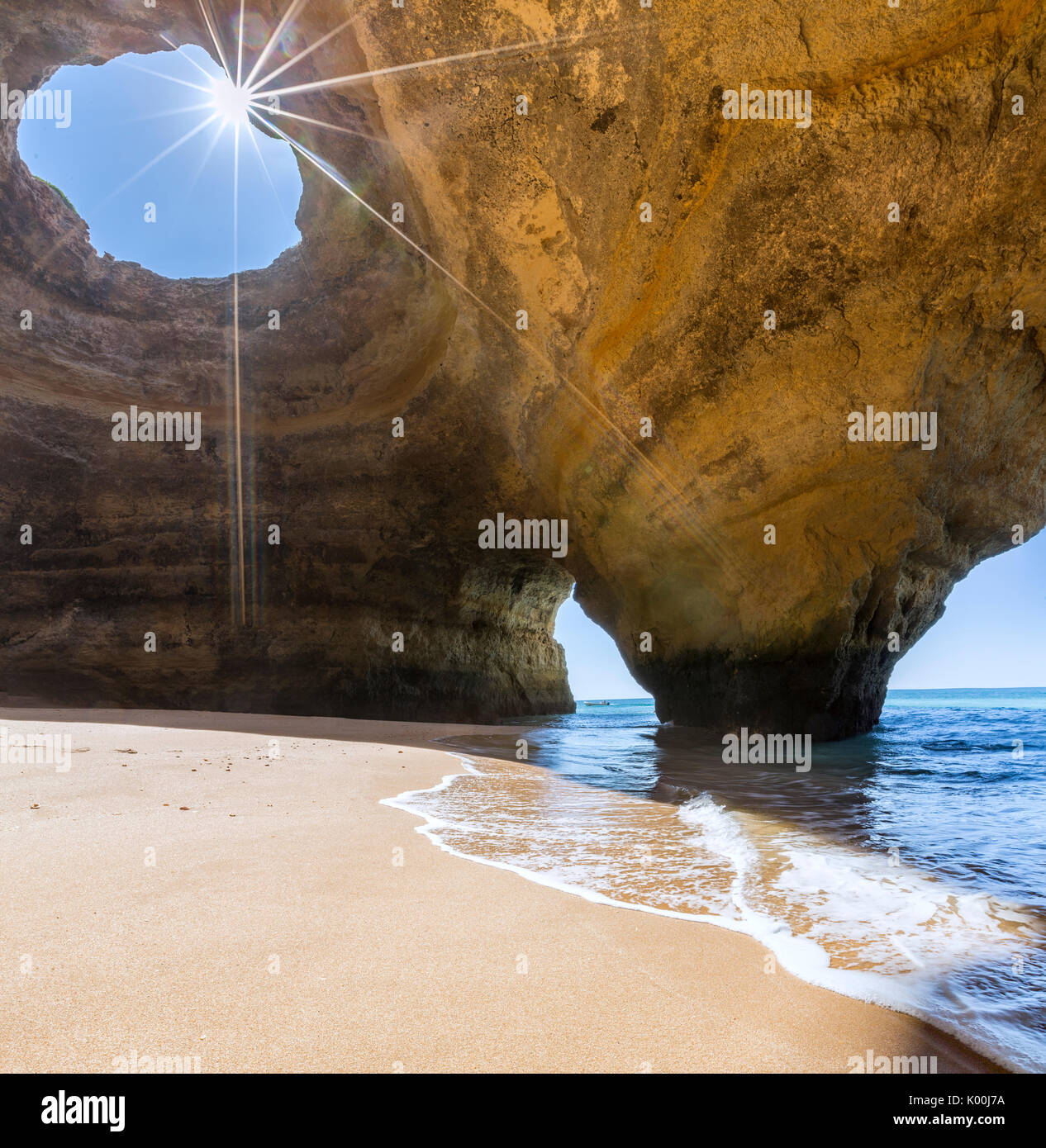 The sun shines through the natural rocky windows inside the caves of Benagil Faro District Algarve Portugal Europe Stock Photo