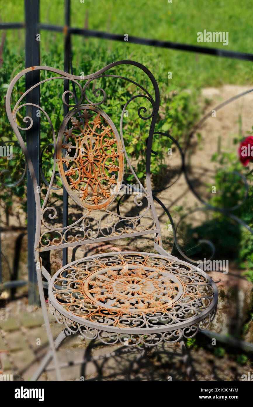 Alter rostiger, romantischer, Stuhl aus Metall, mit verspielten Ornamenten Stock Photo