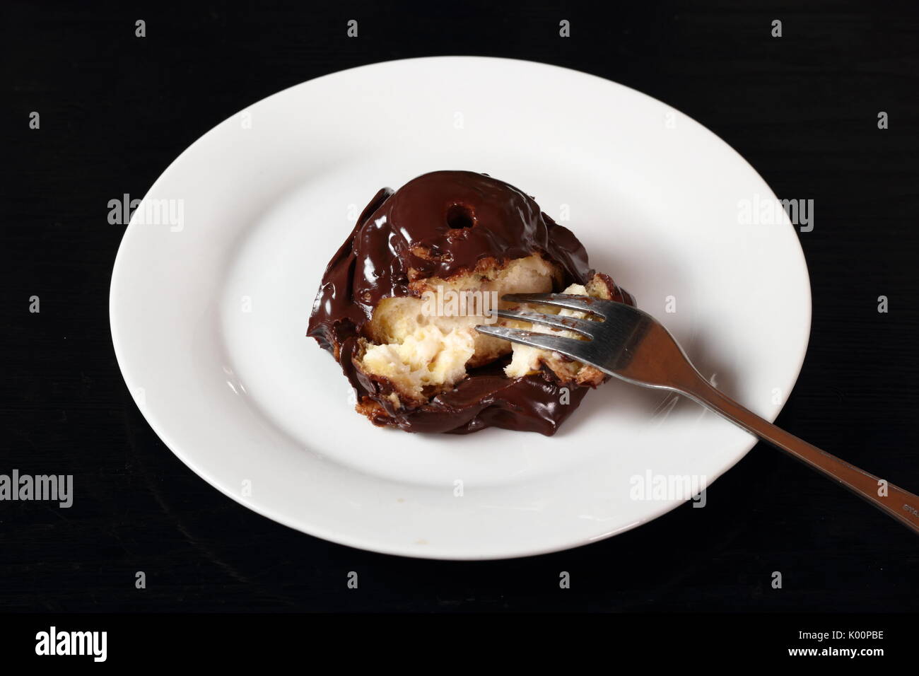 Profiterole with chocolate ganache frosting.  Choux pastry ball with custard filling and chocolate sauce icing. Stock Photo