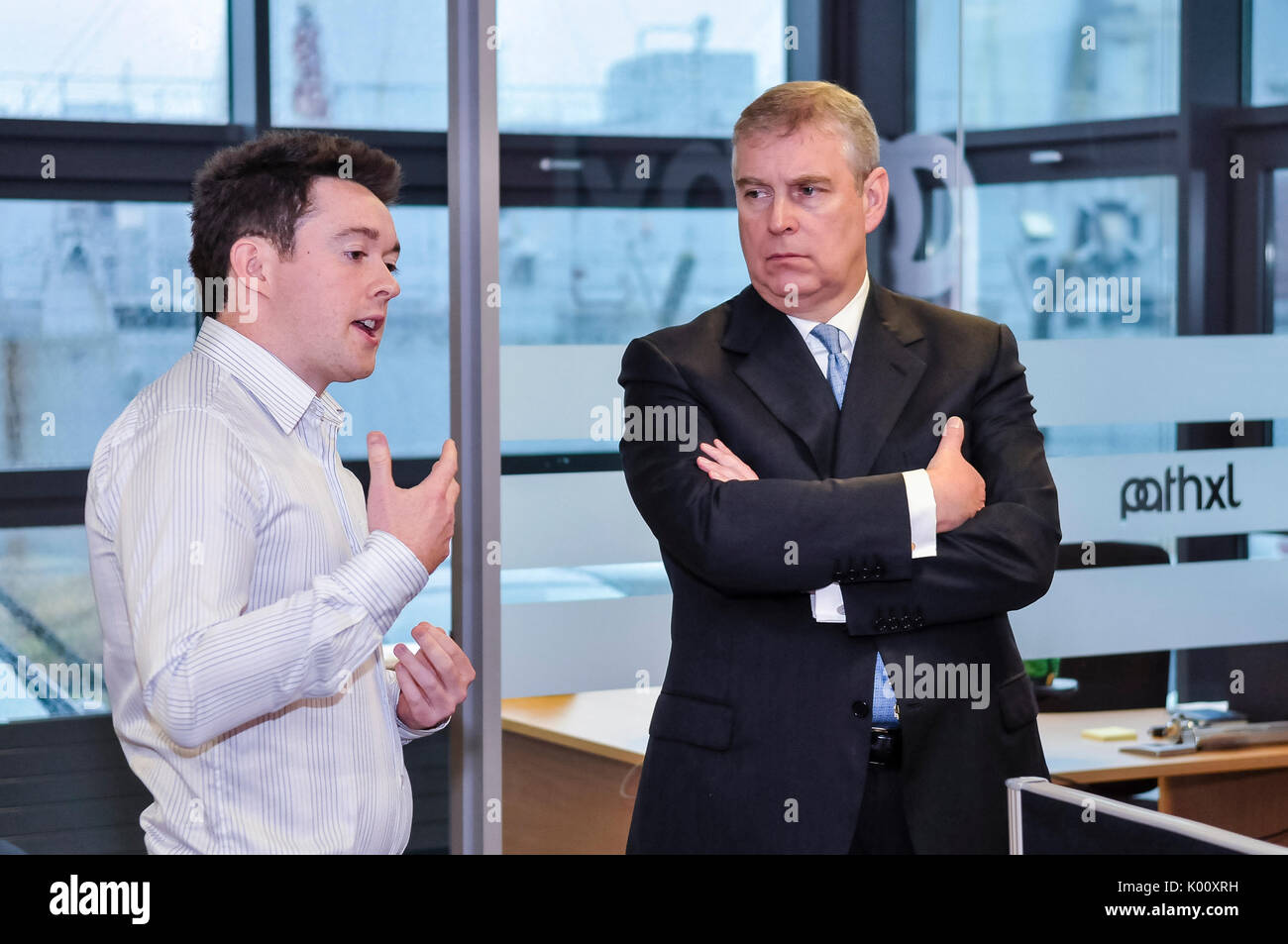 29th January 2013, Belfast, Northern Ireland. Prince Andrew, the Duke of York, stands with his arms folded and a stern face while in conversation with a software engineer at the Northern Ireland Science Park Stock Photo