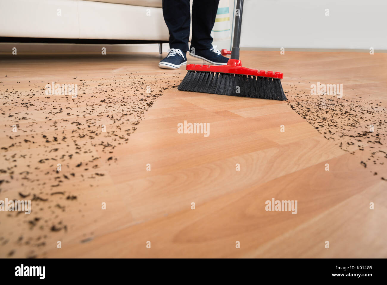 High Angle View Of Broom Cleaning Dirt On Hardwood Floor At Home