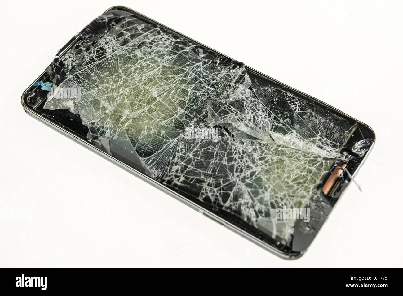 Mobile phone with a badly shattered screen after a serious fall. Stock Photo