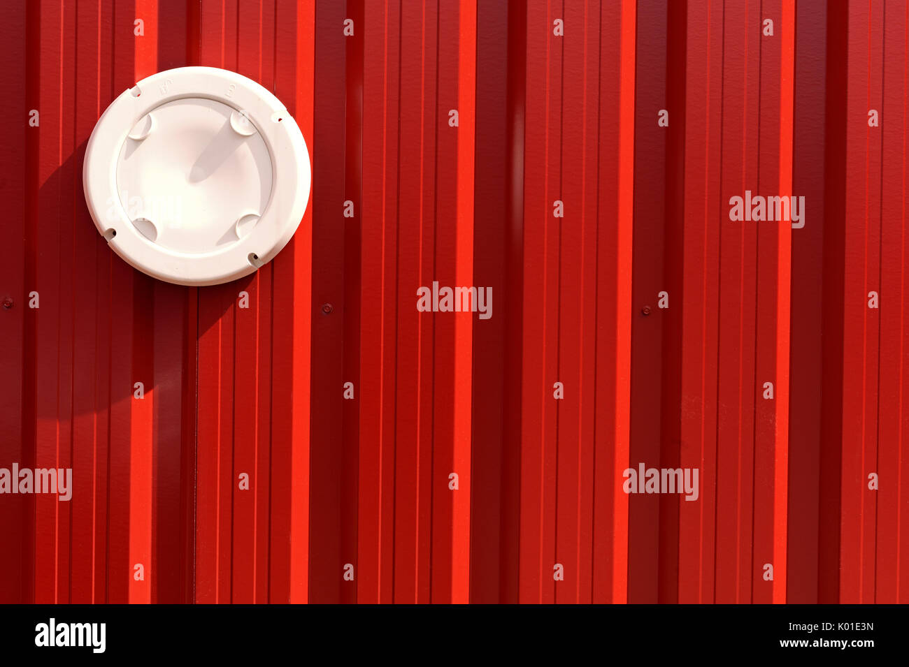 white disc on red wall Stock Photo