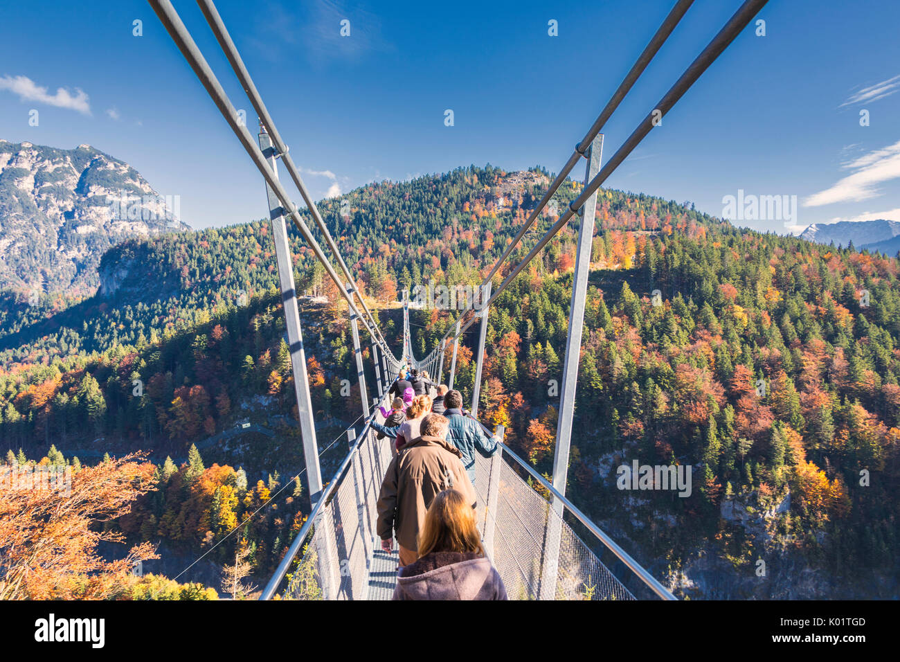 Tourists on the suspension bridge called Highline 179 framed by colorful woods in autumn Ehrenberg Castle Reutte Austria Europe Stock Photo