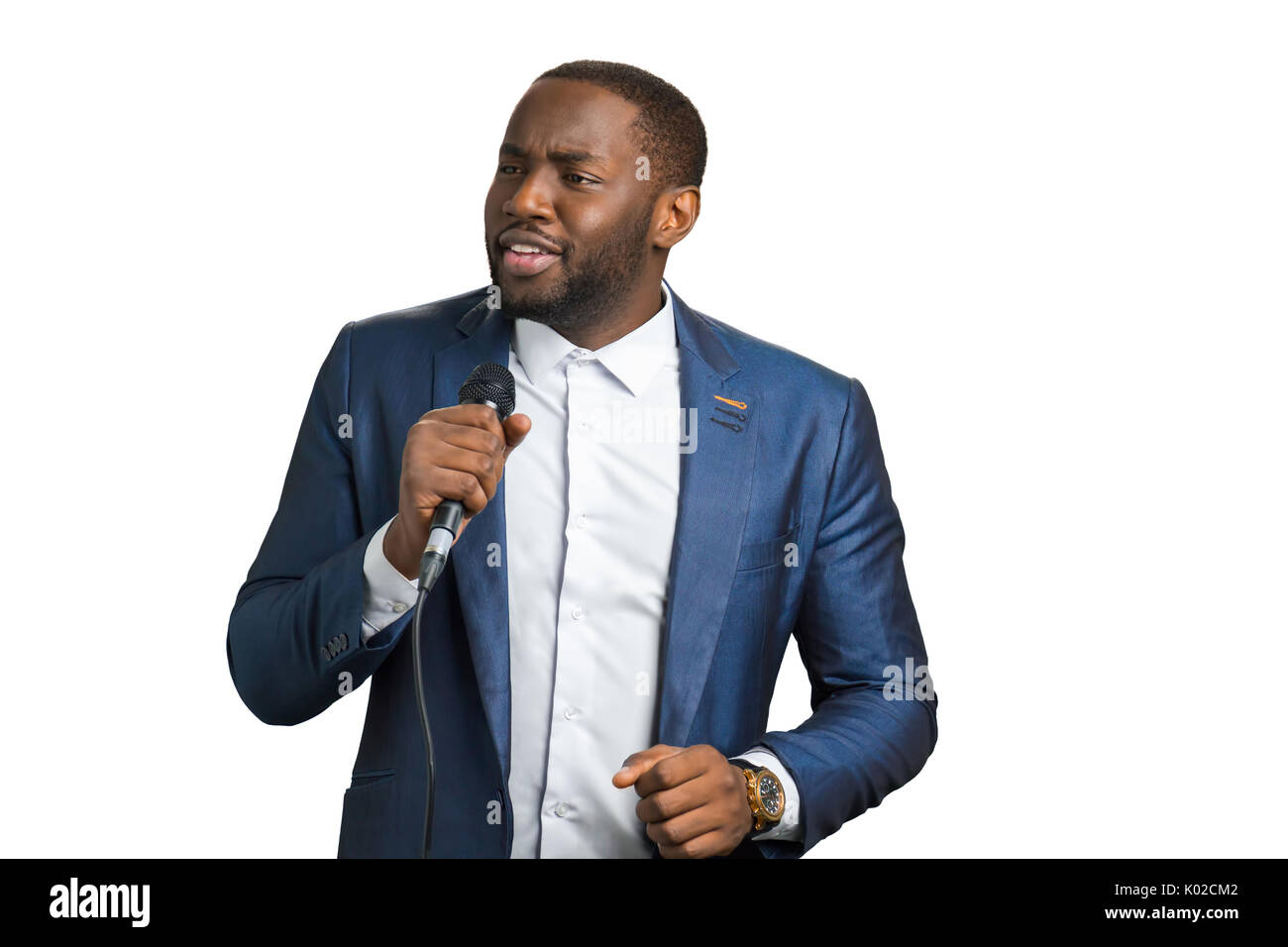Professional jazz singer, white background. Afro american man in elegant suit with microphone. Black singing artist. Stock Photo