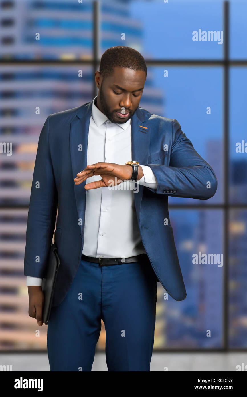 Businessman checking the time on his wrist watch. Young manager is ...