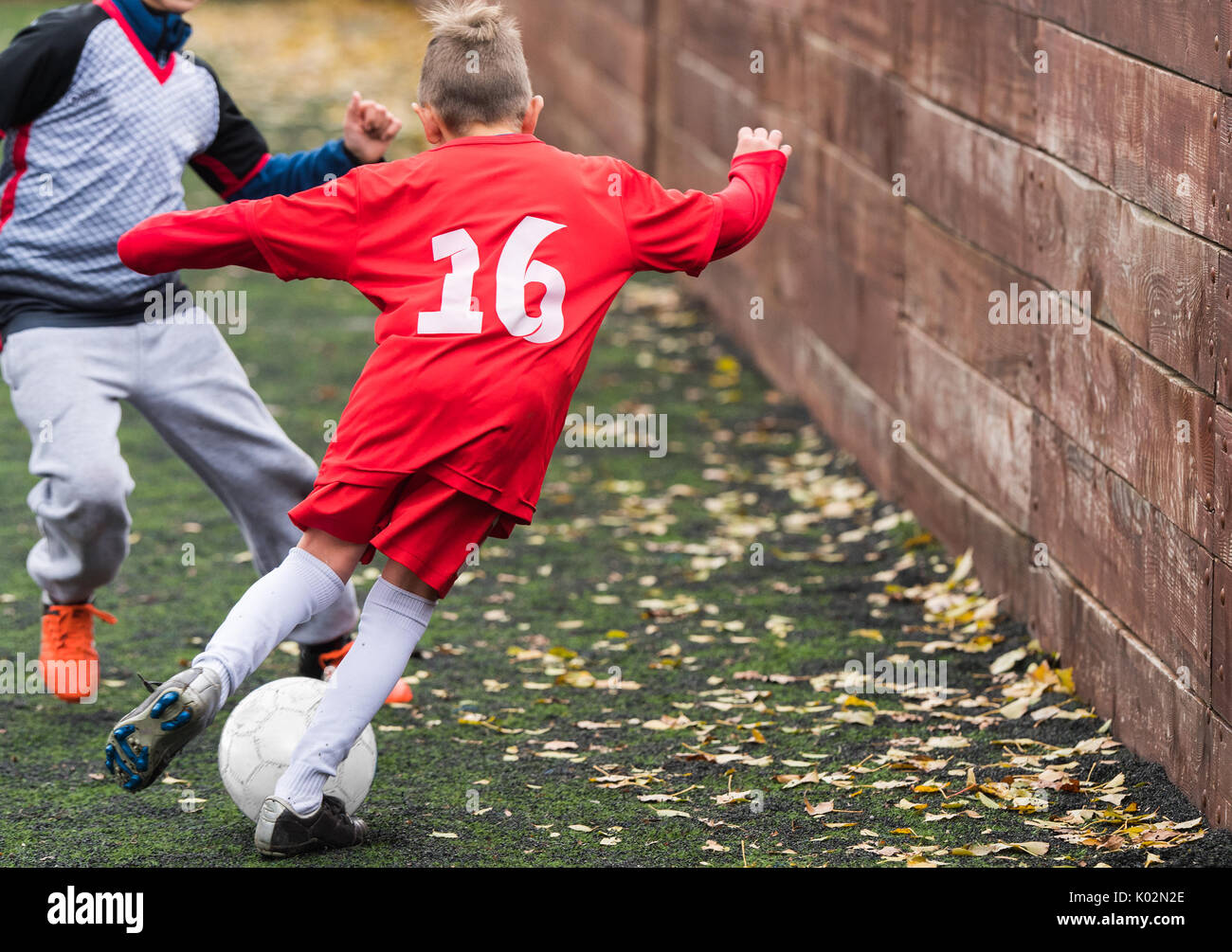 Boys kicking football on the sports field Stock Photo Alamy