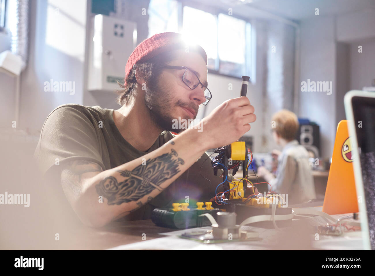 Focused young male designer assembling robotics in workshop Stock Photo