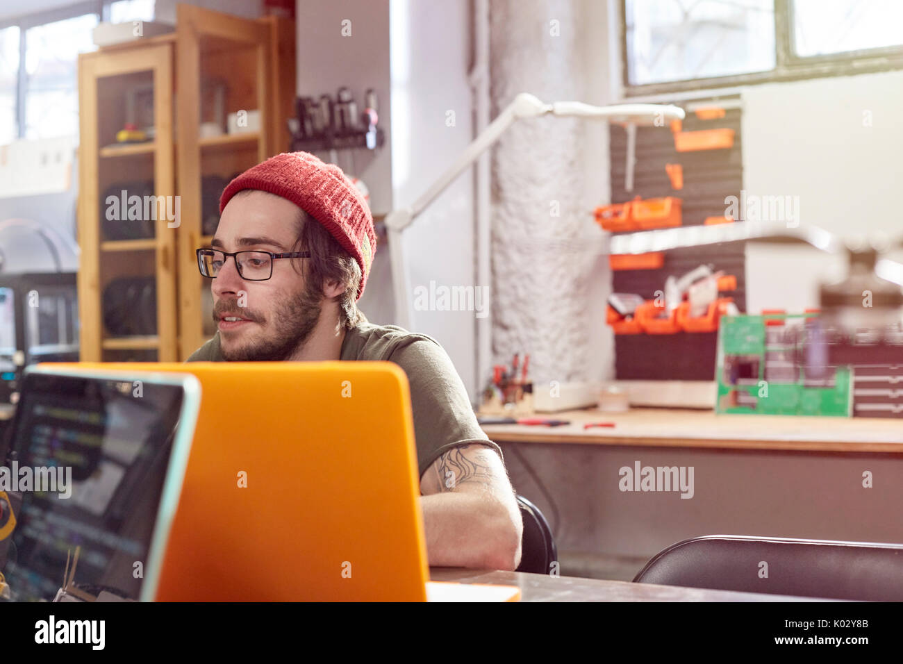 Male designer working at laptop in workshop Stock Photo