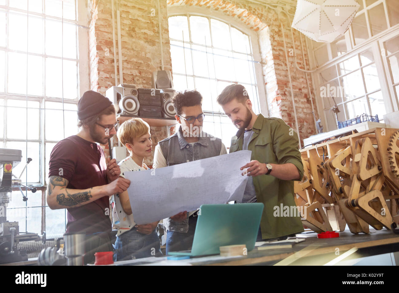 Designers examining blueprints in workshop Stock Photo