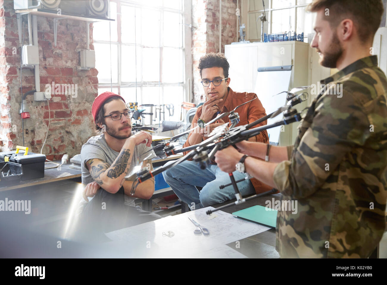 Designers meeting, examining drone in workshop Stock Photo