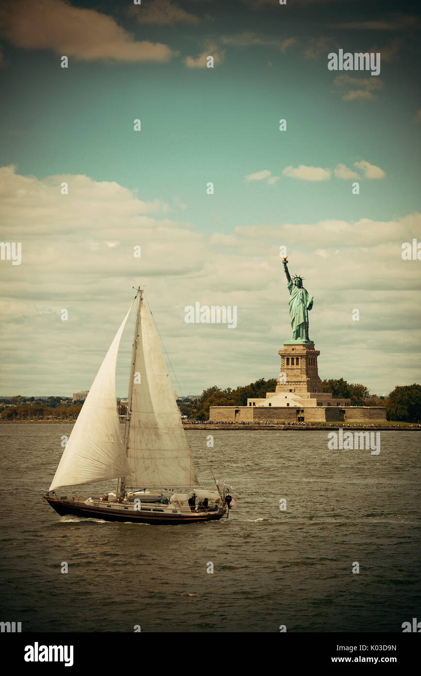 Statue of Liberty at New York City harbor with sailing boat Stock Photo