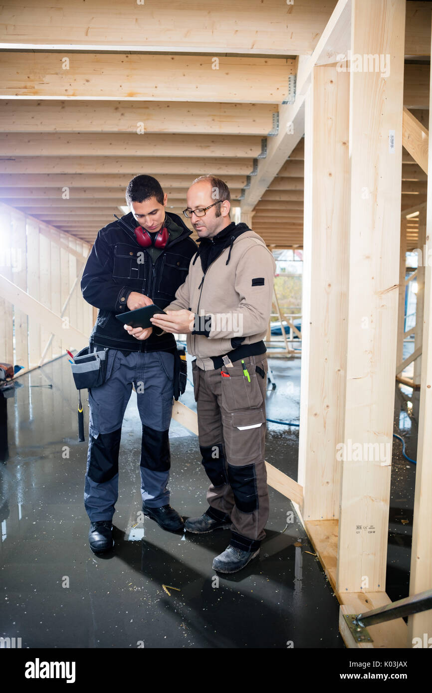 Carpenters Using Tablet Computer At Site Stock Photo
