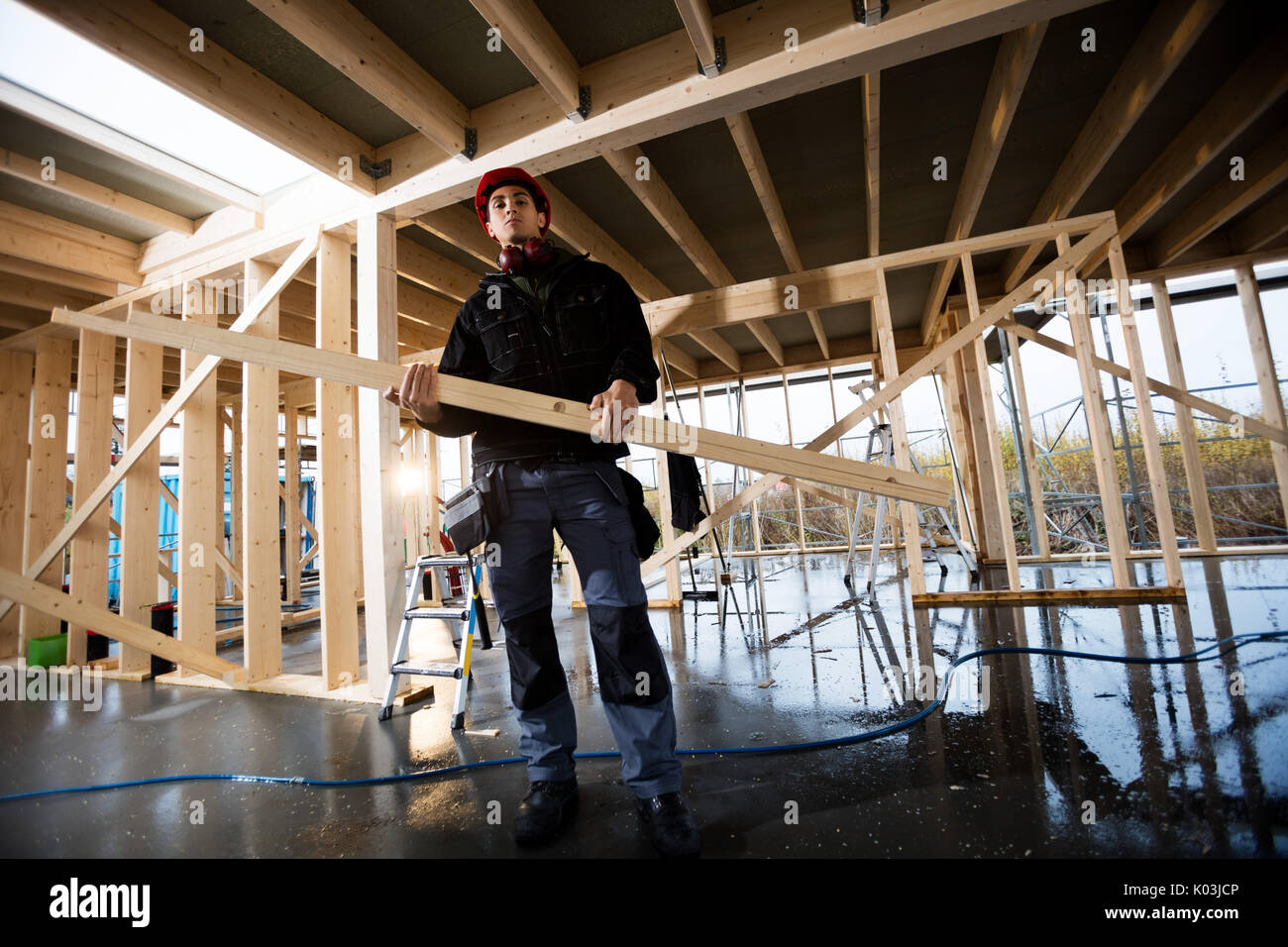 Portrait Of Carpenter Carrying Wood At Site Stock Photo