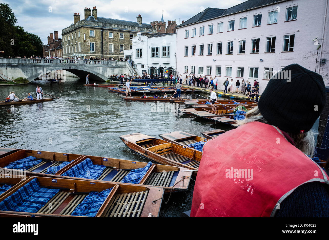 Big Issue Seller looks out over punts on the River Cam in Cambridge UK Stock Photo